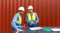 Shipment worker pointing at shipping schedule on clipboard, explain to colleague about planning for next shipment. They use solar Royalty Free Stock Photo