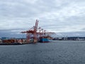 Shipping boat unloaded in Seattle harbor by red cranes Royalty Free Stock Photo