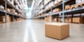 Cardboard delivery box standing on warehouse floor with shelving and inventory in blur background Royalty Free Stock Photo