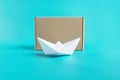 Shipping cargo concept. Paper ship and craft box front view isolated blue background Royalty Free Stock Photo