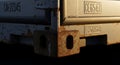 Closeup of a weathered shipping container corner with visible rust and identification numbers Royalty Free Stock Photo