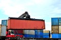 Shipping container loading by richtracker on the freight rail car at logistic warehouse port.