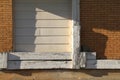 Shipping door abandoned brick warehouse sunny shadows Royalty Free Stock Photo