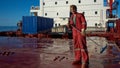 Ships crew members painting hatch cover outdoors with bright blue sky on a background. Ship maintenance concept