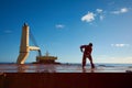 Ships crew members painting hatch cover outdoors with bright blue sky on a background. Ship maintenance concept Royalty Free Stock Photo