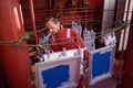 Ships crew members painting hatch cover outdoors with bright blue sky on a background. Ship maintenance concept