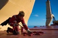 Ships crew members painting hatch cover outdoors with bright blue sky on a background. Ship maintenance concept
