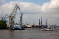 Docked at an industrial port with cargo cranes and a helicopter in the background, Hamburg Royalty Free Stock Photo