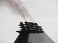 Ships funnel emitting black smoke in the sky Royalty Free Stock Photo