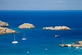 Ships on the Mediterranean blue lagoon. Greek rocky cliffs and t