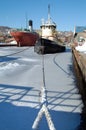 Ships sit idle in harbor encased with ice