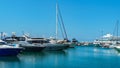 Ships, yachts and boats on blue surface of Black Sea by pier of Commercial seaport of Sochi. Resort city center. Royalty Free Stock Photo