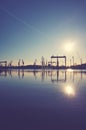 Shipyard cranes silhouettes reflected in water at sunset Royalty Free Stock Photo