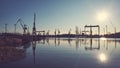 Shipyard cranes silhouettes reflected in water at sunset Royalty Free Stock Photo