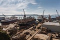 shipyard with view of the ocean, surrounded by busy work of seamen and shipbuilders