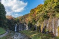 Shiraito Waterfall in autumn season with green and red maple tree and blue sky. Royalty Free Stock Photo