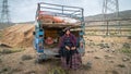 Qashqai nomadic woman sitting by an old car, Shiraz, Iran