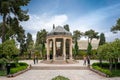 Shiraz, Iran - 04.14.2019: People walking in persian garden with a stone gazebo. Tomb of Hafez Shirazi, famous persian