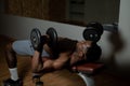 Shirtless afro american man doing exercises with dumbbells lying on bench in gym. Royalty Free Stock Photo