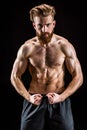 Shirtless bearded bodybuilder posing isolated on black