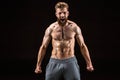 Shirtless bearded bodybuilder posing and yelling isolated on black