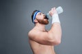 Shirtless bearded sportsman drinking water from plastic bottle Royalty Free Stock Photo