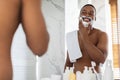 Shirtless Black Guy Looking At Mirror And Applying Shaving Foam In Bathroom Royalty Free Stock Photo