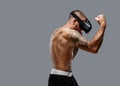 Shirtless brutal boxing fighter in virtual reality glasses.