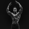 Shirtless male bodybuilder with muscular build strong abs showing rising hand Royalty Free Stock Photo