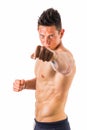 Shirtless male model throwing punch towards camera Royalty Free Stock Photo