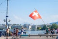 Shirtless male tourists in front Flag of the flag of Switerland in the city center of Geneva, on the Leman lake