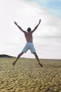 Shirtless Man Doing Star Jump On Beach Royalty Free Stock Photo