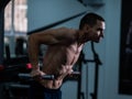 Shirtless man doing triceps dips from parallel bars in gym. Royalty Free Stock Photo
