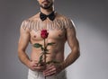 Shirtless man standing with flower