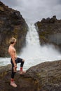 Shirtless and muscular boy looks at the Aldeyjarfoss waterfall in Iceland