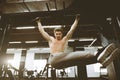 Shirtless muscular handsome young man doing exercises on horizontal bar in a gym club. Royalty Free Stock Photo