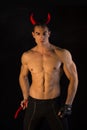 Shirtless muscular male bodybuilder dressed with devil costume Royalty Free Stock Photo