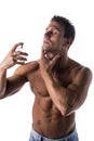Shirtless muscular male model spraying cologne Royalty Free Stock Photo