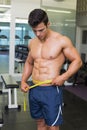 Shirtless muscular man measuring waist Royalty Free Stock Photo