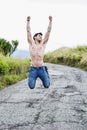 Shirtless muscular young man jumping for joy