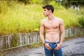 Shirtless muscular young man walking on rural road