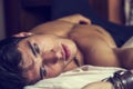 Shirtless male model lying alone on his bed Royalty Free Stock Photo