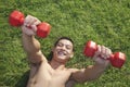 Shirtless, smiling, muscular man exercising with dumbbells in Grass, view from above Royalty Free Stock Photo