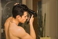 Shirtless young man drying hair with hairdryer Royalty Free Stock Photo