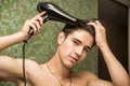 Shirtless young man drying hair with hairdryer Royalty Free Stock Photo