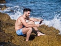 Young man on beach reading with ebook reader Royalty Free Stock Photo