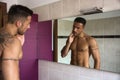 Shirtless young man examining his stubble in mirror Royalty Free Stock Photo