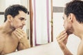 Shirtless young man examining his stubble in mirror Royalty Free Stock Photo