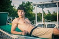 Shirtless Young Man Sunbathing in Lounge Chair on