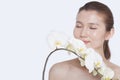 Shirtless young woman with eyes closed smelling a bunch of beautiful white flowers, studio shot Royalty Free Stock Photo